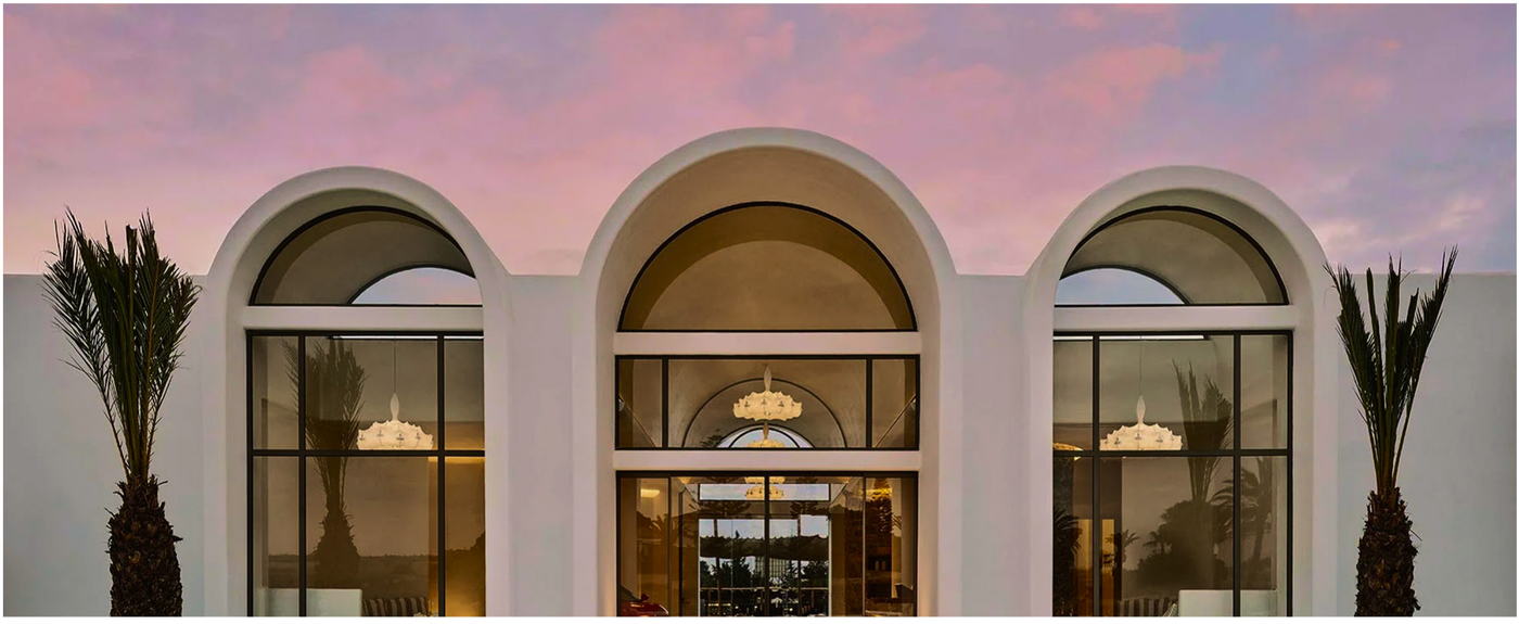 The arched façade at AYÀ Resort at dusk